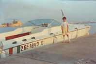 Maurizio 12 anni accanto barca contrabbandiera